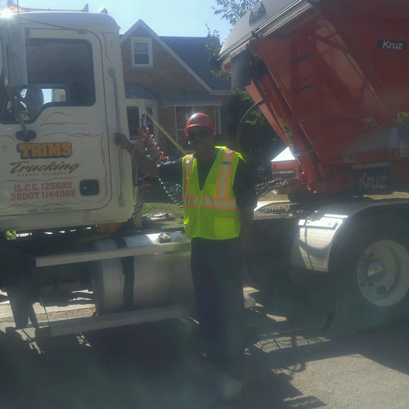 Trim's Trucking operator beside a company truck