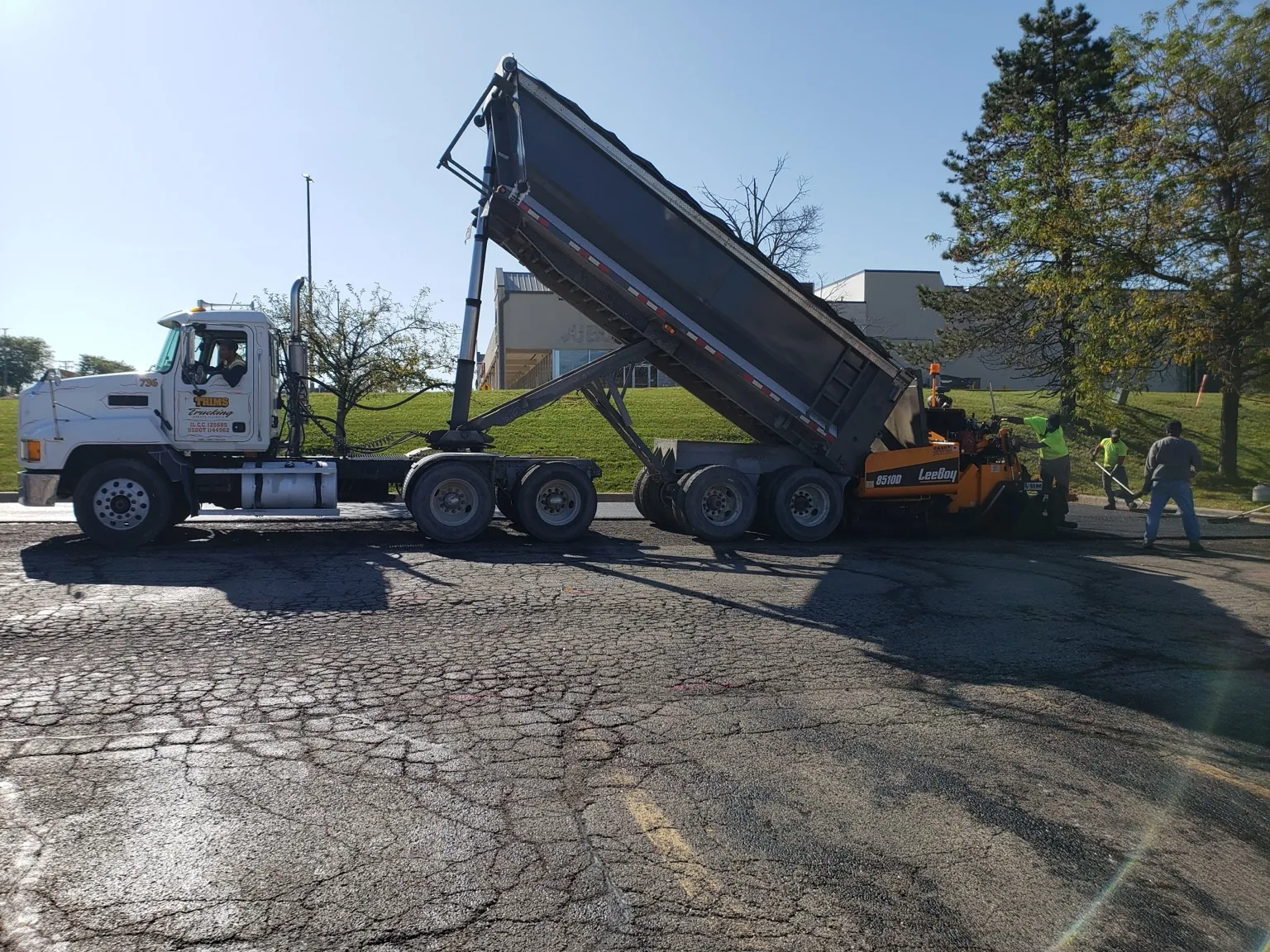 Trim's Trucking dump trailer supporting a road construction crew